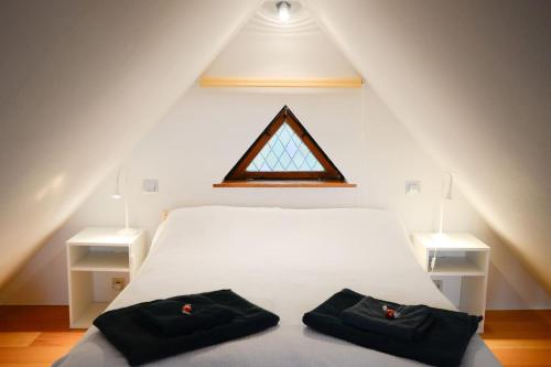 罗斯托克Weitblick-Loft mit Terrasse的卧室配有白色的床和两个黑色的袋子