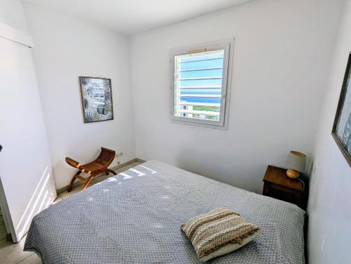 圣吉尔莱班Sunset Océan - appartement T2 avec vue imprenable sur l'océan et piscine的一间卧室设有一张床和一个窗口