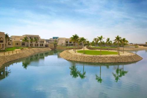 Wādī KhasbarHawana VIP Private Apartment的棕榈树和建筑的水域