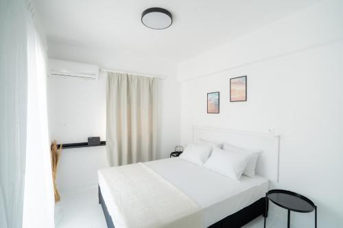 罗希姆诺SyntheSeas Residence的白色的卧室设有床和窗户