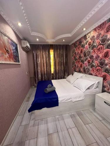 奇姆肯特15 Apartments的一间卧室设有一张带花卉墙壁的大床