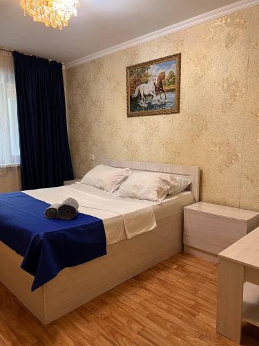 奇姆肯特Апартаменты на Mege的一间卧室配有一张带蓝色毯子的大床