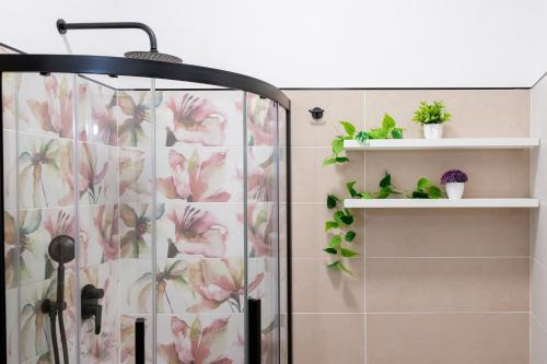 CastelsaracenoLeukòs Bed and Breakfast的浴室设有淋浴,墙上装饰着粉红色的鲜花。