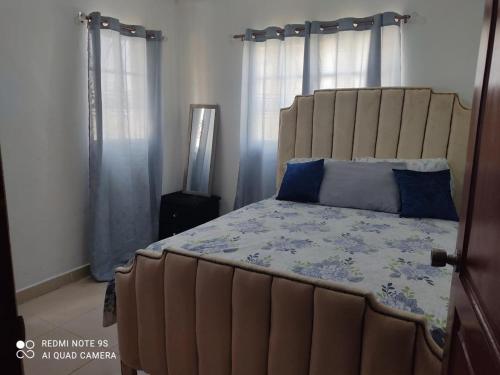 Villa MellaApartamento confortable de 1 habitacion的一间卧室配有一张带蓝色枕头的大床