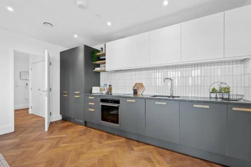 伦敦Luxurious two-bedroom flat with scenic views的一间大厨房,配有灰色橱柜和白色家电