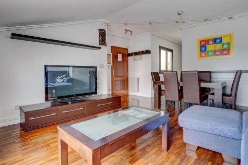 伊伦Luminoso ático con terraza, Irún的客厅配有电视和桌子