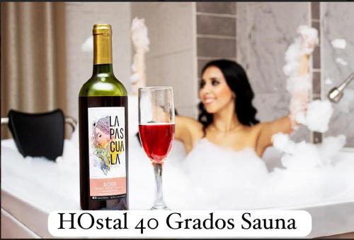 利马HOSTAL SAUNA 40 GRADOS的浴缸里女士旁边的一瓶红酒