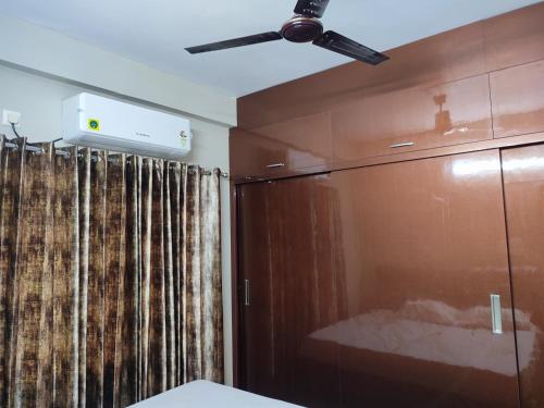 维沙卡帕特南Rahul's Castle Guest House的配有滑动玻璃门的客房内的吊扇