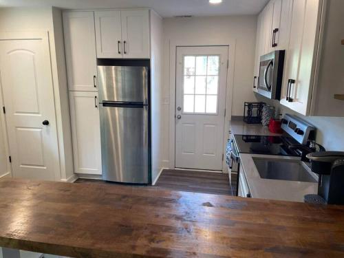 格林维尔Charming 2Br, Fully Equipped kitchen, Smart TV的厨房配有不锈钢冰箱