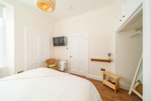 BirnamDreamy Town House Apartment in Dunkeld的白色卧室设有白色的床和木地板
