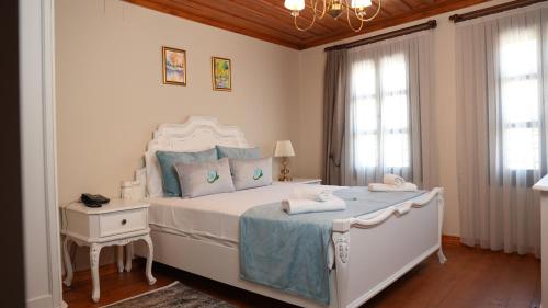 SokeDomatia Stone Hotel的卧室配有带蓝色枕头的大型白色床