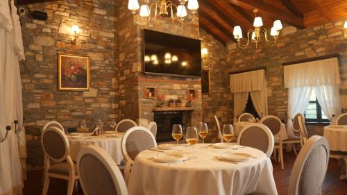 SokeDomatia Stone Hotel的餐厅设有白色的桌椅和壁炉