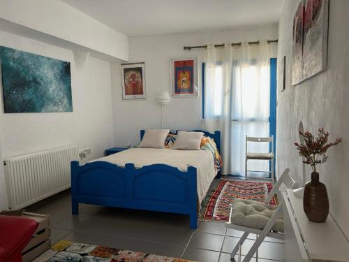 PendakomoEndless Sunset的一间卧室配有蓝色的床和椅子