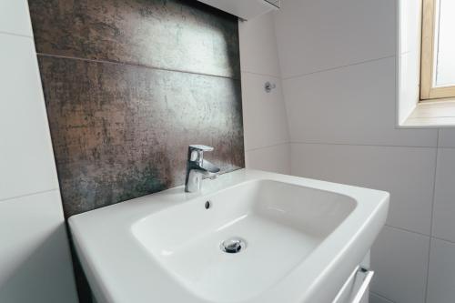 克拉根福Stadtapartment KUS的浴室内设有带水槽的白色浴缸