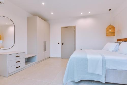 帕尔加MiLiON RESIDENCES的白色卧室配有床和镜子