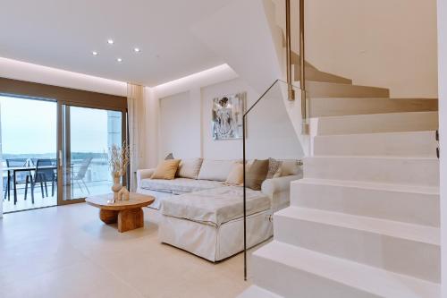 帕尔加MiLiON RESIDENCES的白色的客厅设有楼梯和沙发