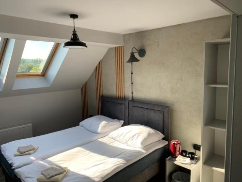 格丁尼亚Guest Apartments Orłowo的一间卧室配有一张带白色床单的床和一扇窗户。