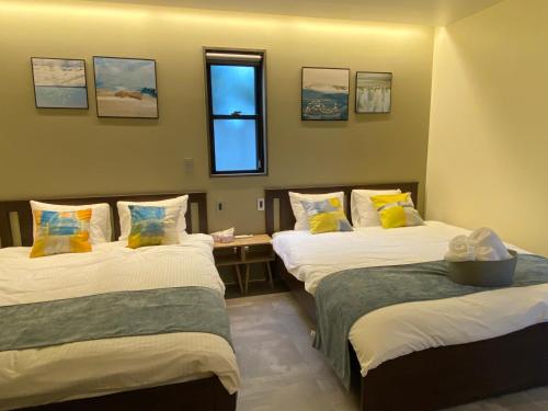 吉马Sky Blue Villa沖縄的客房设有两张床和窗户。