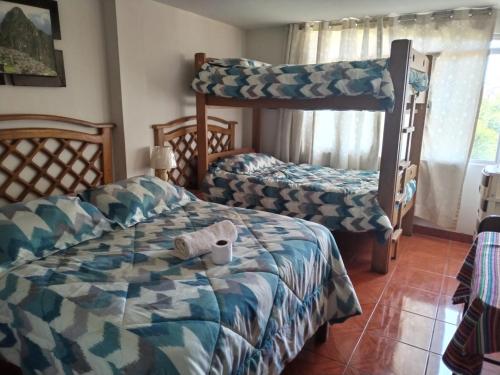 利马Hostal Turístico El Cajamarquez的一间卧室配有两张床和一张双层床。
