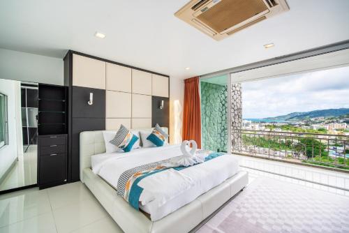 芭东海滩patong villa2：四卧泳池别墅/两个海景房/近班赞酒吧街的一间卧室设有一张大床和一个大窗户