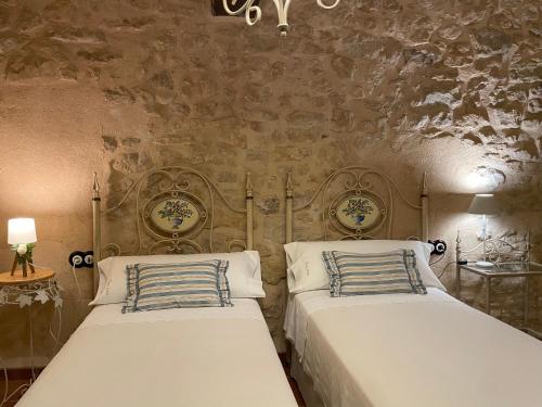 瓦德诺比斯Casa Lidia - Antigua Posada Real的卧室设有两张床铺和石墙