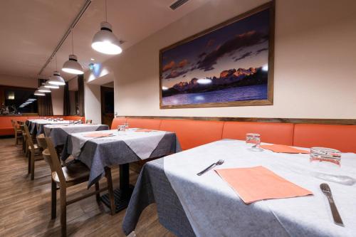 摩德纳迪-坎皮格里奥弗蒂尼酒店的餐厅的一排桌子,有白色桌布