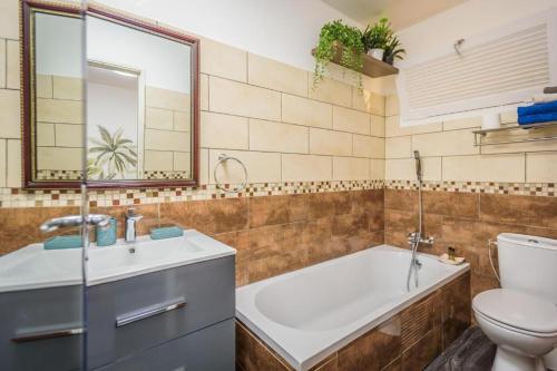 圣丹尼斯1A - Chambres et Appartements au calme - Centre St Denis - Barachois的带浴缸、卫生间和盥洗盆的浴室