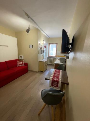 奥斯塔Monolocale piccolo ed accogliente - CIR 0021 -的客厅配有红色的沙发和桌子