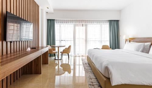 迪拜Pyramisa Hotel Apartments的酒店客房设有一张大床和一张桌子。
