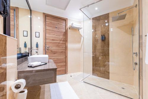 迪拜Pyramisa Hotel Apartments的带淋浴和盥洗盆的浴室