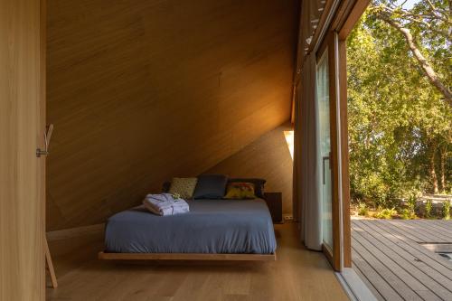马林Cabañas de Xarás, Mimosa的小型客房的一张床位,设有门廊