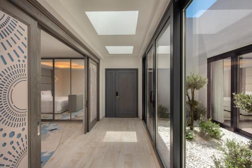 圣朱利安斯The Westin Dragonara Resort, Malta的走廊上设有玻璃门和床,距离公寓不远