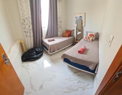 卡皮托利乌Apartamento的客房设有两张床,铺有大理石地板。