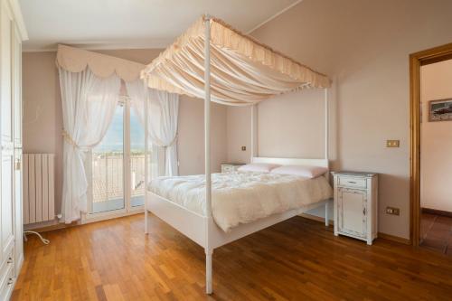 奥西莫La Gipsofila Attic的一间卧室配有一张天蓬床和窗户