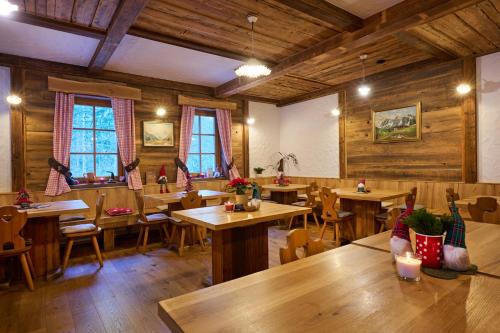 索尔察瓦Eko hiša-Eco House Na razpotju的餐厅设有木桌、椅子和窗户。