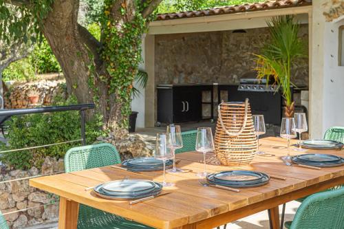 土伦La Villa Jausserane的一张木桌,上面放有盘子和酒杯