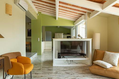 土伦La Villa Jausserane的客厅配有大电视和橙色椅子
