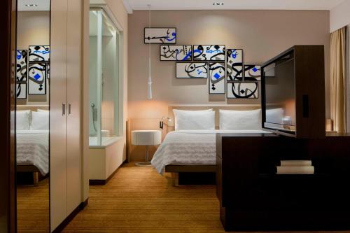 麦纳麦巴林墨丽婷市中心酒店的酒店客房,配有床和镜子