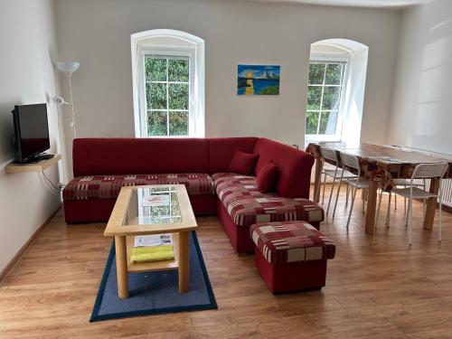 普拉哈季采Apartmán v Zahradní的客厅配有红色的沙发和桌子