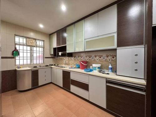 峇六拜Muslim Suite Home @ Airport Bayan Lepas Penang的一间大厨房,配有白色和棕色的橱柜
