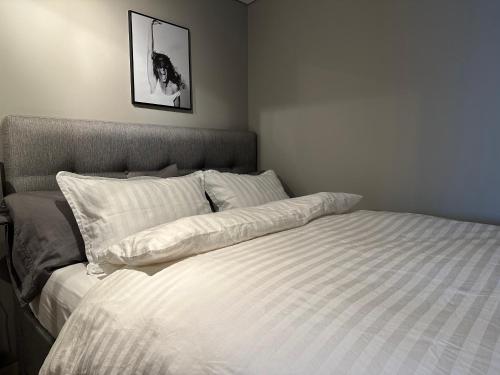 莫斯费德斯拜尔Cosy lakeview cabin 45 minutes from Reykjavik的卧室内的一张带白色床单和枕头的床