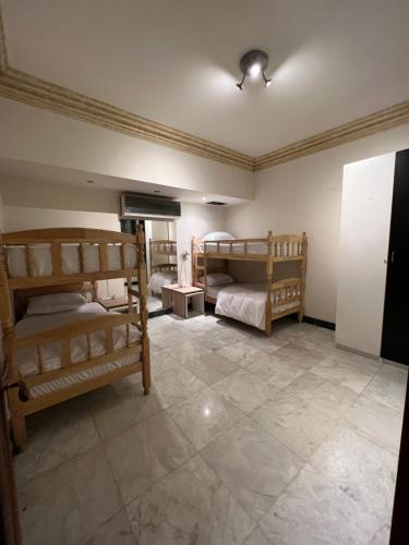 开罗The GlassHouse Pool的一间带两张双层床的卧室,铺有瓷砖地板。