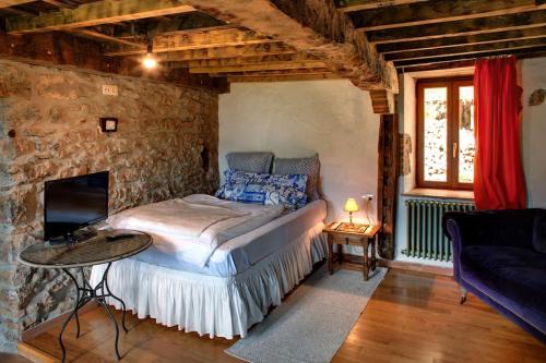 利亚内斯El nido de la golondrina的一间卧室设有一张床和石墙