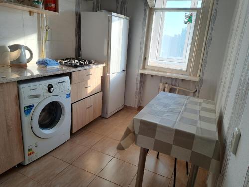 基希讷乌Dacia的厨房配有洗衣机和桌子