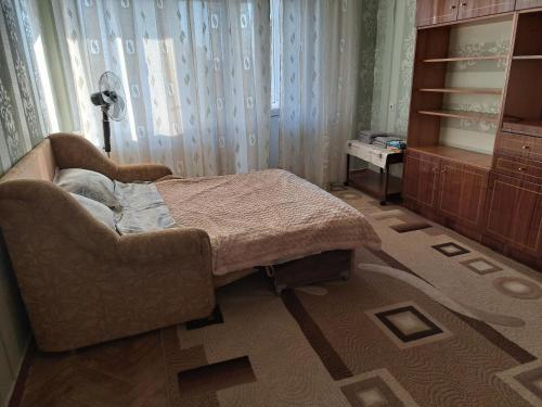 基希讷乌Dacia的卧室配有床、椅子和窗户。