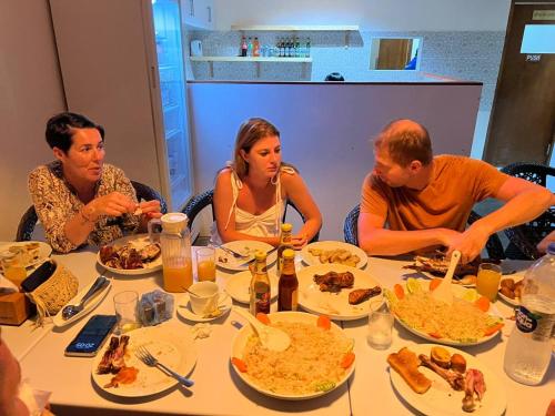 图鲁斯杜Aasna Inn的一群坐在桌子旁吃食物的人