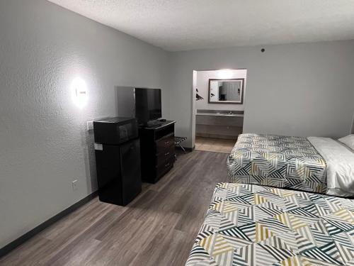 俄克拉何马城Motel 6 Oklahoma City OK Fairgrounds West的酒店客房设有两张床和电视。