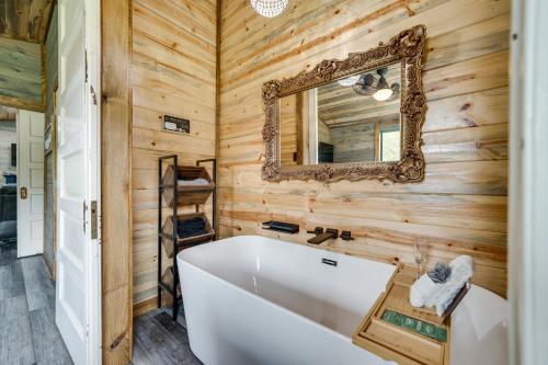 布罗肯鲍Riverfront Broken Bow Cabin with Private Hot Tub!的浴室配有白色浴缸和镜子