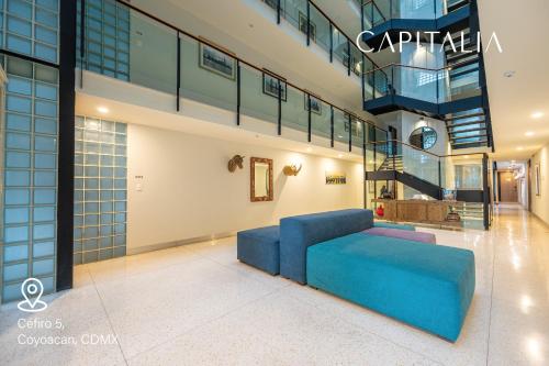 墨西哥城Capitalia - Apartments - CÉFIRO CINCO的大楼内带蓝色沙发的客厅
