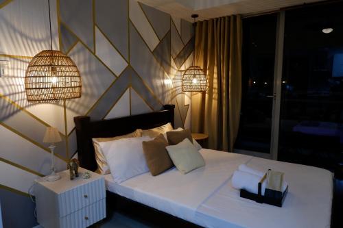 马尼拉Azure Urban Beach Resort by Melrose Avenue的一间卧室配有一张带两盏灯的大型白色床。